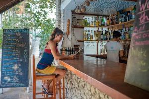 a woman sitting at a counter in a bar at The Blue Orchid Resort in Moalboal