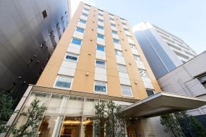a tall brown building with windows in a city at Hotel Villa Fontaine Tokyo-Hamamatsucho in Tokyo