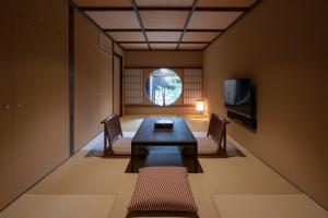 a dining room with a table and chairs and a window at Mimari Machiya House in Kanazawa