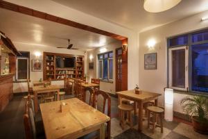 un ristorante con tavoli e sedie in legno e una TV di Pacific Guest House a Kathmandu