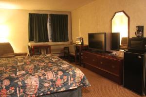 a hotel room with a bed and a flat screen tv at Garden City Inn in Garden City