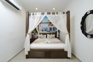 a bedroom with a canopy bed with a mirror at Hotel de Art @ Section 19 in Shah Alam