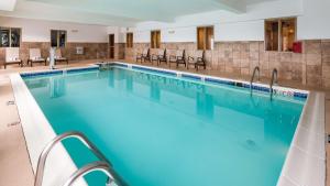 Best Western Providence-Seekonk Inn في سيكونك: مسبح كبير مع كراسي في الفندق