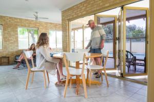 a group of people sitting at a table in a house at Lancelin Lodge in Lancelin