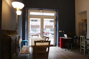 une chambre avec une table, des chaises et une porte en verre dans l'établissement Bamboo Eco Hostel, à Turin