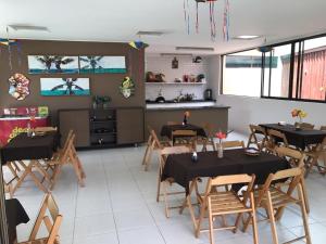 un restaurante con mesas y sillas en una habitación en Muro Alto - Nui Supreme, en Ipojuca