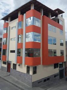 un edificio con acentos rojos en el lateral. en Hostal Capac, en Ayacucho