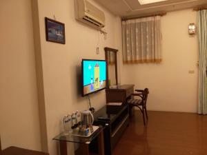 sala de estar con TV y mesa en Feng Lin Homestay, en Shuili