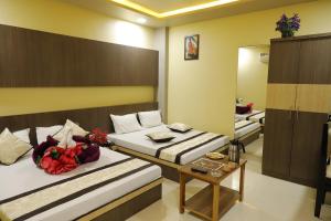 a hotel room with two beds and a mirror at Hotel Royal Suites in Ajmer