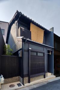 Tsumugi Kiyomizugojo في كيوتو: منزل أسود مع بوابة سوداء وسياج