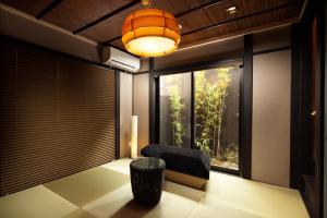 Tsumugi Kiyomizugojo في كيوتو: غرفة معيشة مع كرسي ونافذة