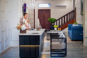 a woman sitting at a counter in a room at Blanc Smith Residence in Siem Reap