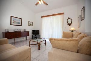 salon z 2 kanapami i telewizorem w obiekcie The Olive Grove Villa Private Pool with star links WiFi w mieście Theologos