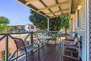 a patio with chairs and a table on a deck at The Cove Holiday Village in Point Samson