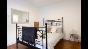 a bedroom with a black bed and a mirror at The Cottage in Aberdeen