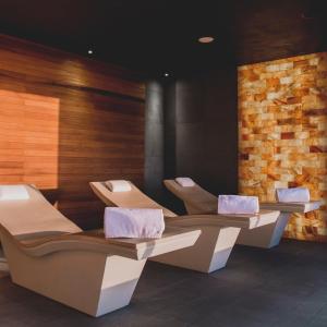 a waiting room with four chairs and a brick wall at Mysk Al Faya Retreat in Sharjah