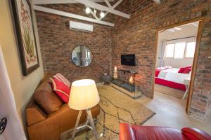 a brick walled room with a couch and a bedroom at Route 40 in Hoedspruit