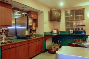 a kitchen with wooden cabinets and green counter tops at Garden City Inn in Garden City
