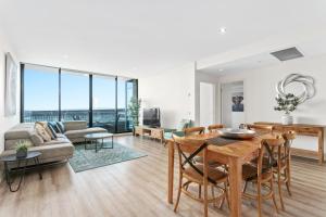 sala de estar con mesa y sofá en Waterfront Melbourne Apartments en Melbourne