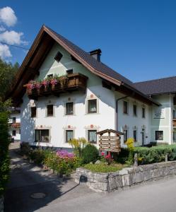 un bâtiment blanc avec des boîtes de fleurs sur lui dans l'établissement Gästehaus Hosp, à Reutte