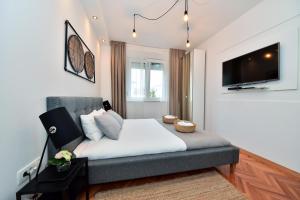 Schlafzimmer mit einem Bett und einem Flachbild-TV in der Unterkunft Viatorem in Zadar