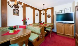 a living room with a television and a dining room at Gästehaus Hosp in Reutte