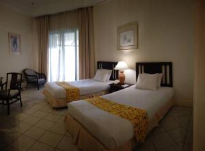 A bed or beds in a room at The Orient Star Resort Lumut