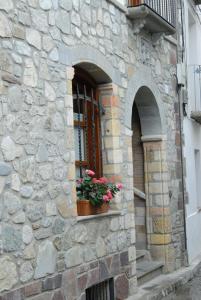 un edificio de piedra con una ventana con flores. en Apartamentos Sorripas 1 hab, en Bielsa