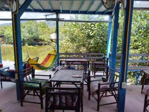 a group of chairs and tables with hammocks on a porch at Lakchai Resort in Ko Chang