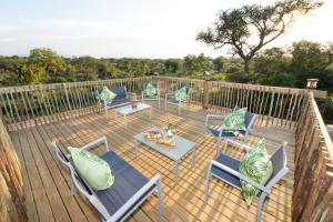 a wooden deck with chairs and tables on it at Route 40 in Hoedspruit