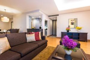 a living room with a couch and a table at Ascott Sathorn Bangkok - SHA Plus Certified in Bangkok