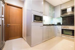 a kitchen with a microwave, refrigerator, sink and dishwasher at Ascott Sathorn Bangkok - SHA Plus Certified in Bangkok