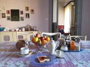 een tafel met een fruitschaal en een bord eten bij Maison Decò in Catania