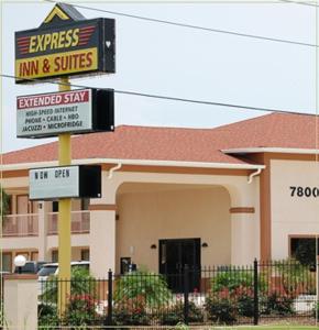 uma estalagem e suites assinam em frente a um edifício em Express Inn & Suites Westwego em Westwego