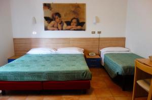 sypialnia z 2 łóżkami i obrazem na ścianie w obiekcie Hotel Serena w mieście Riolo Terme