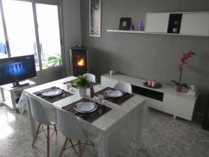 a living room with a table and chairs and a television at Edificio Thailandia 2, 9G in Santa Pola
