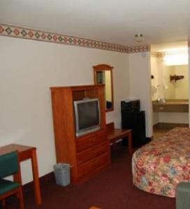 um quarto de hotel com uma cama e uma televisão em Express Inn & Suites Westwego em Westwego