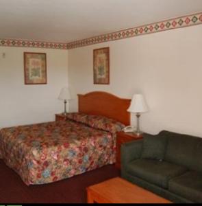 a hotel room with a bed and a couch at Express Inn & Suites Westwego in Westwego