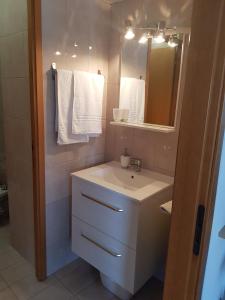 La salle de bains est pourvue d'un lavabo, d'un miroir et de serviettes. dans l'établissement Apartment Schiavoni, à Fano