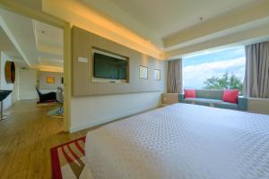 a hotel room with a television and a bed at Mercure Penang Beach in George Town