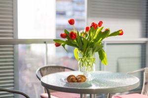 a glass vase with red flowers on a table at Ivan and Hrvoje Apartments in Split