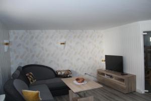 uma sala de estar com um sofá e uma televisão em Ferienwohnung Frau Holle em Witzenhausen