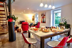 comedor con mesa y sillas rojas en Chambre d'Hôtes de Suzette, en La Forêt-Fouesnant