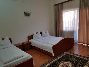 a hotel room with two beds and a window at Vila Orhidee in Eforie Nord