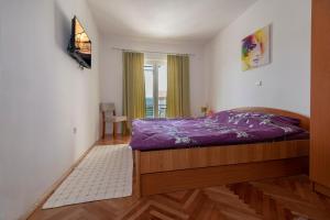 a bedroom with a purple bed and a window at Apartments & rooms Leon in Neum