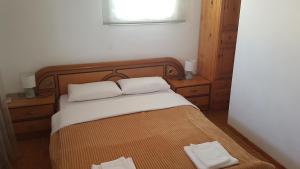a bedroom with a bed with two white towels on it at G-George Apartments by the Sea and Airport in Liádha