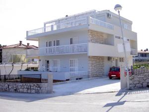 un edificio blanco con un coche aparcado delante de él en Guesthouse Novak, en Hvar