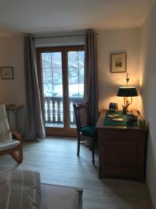 a room with a desk with a lamp and a window at Apartment Ape Maja in Bad Wiessee