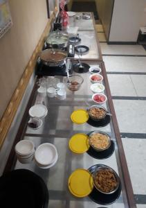 un lungo tavolo con molti piatti e ciotole di cibo di Hotel Kalinga Lake View a Ahmedabad