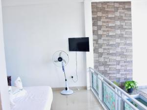 a room with a fan and a tv on a wall at Ornateview Hotel in Ella